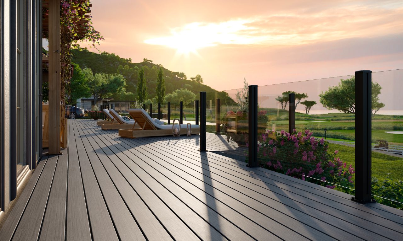 Trex X-Series frameless glass railing on a Trex deck at sunset with a beautiful beach in the background.